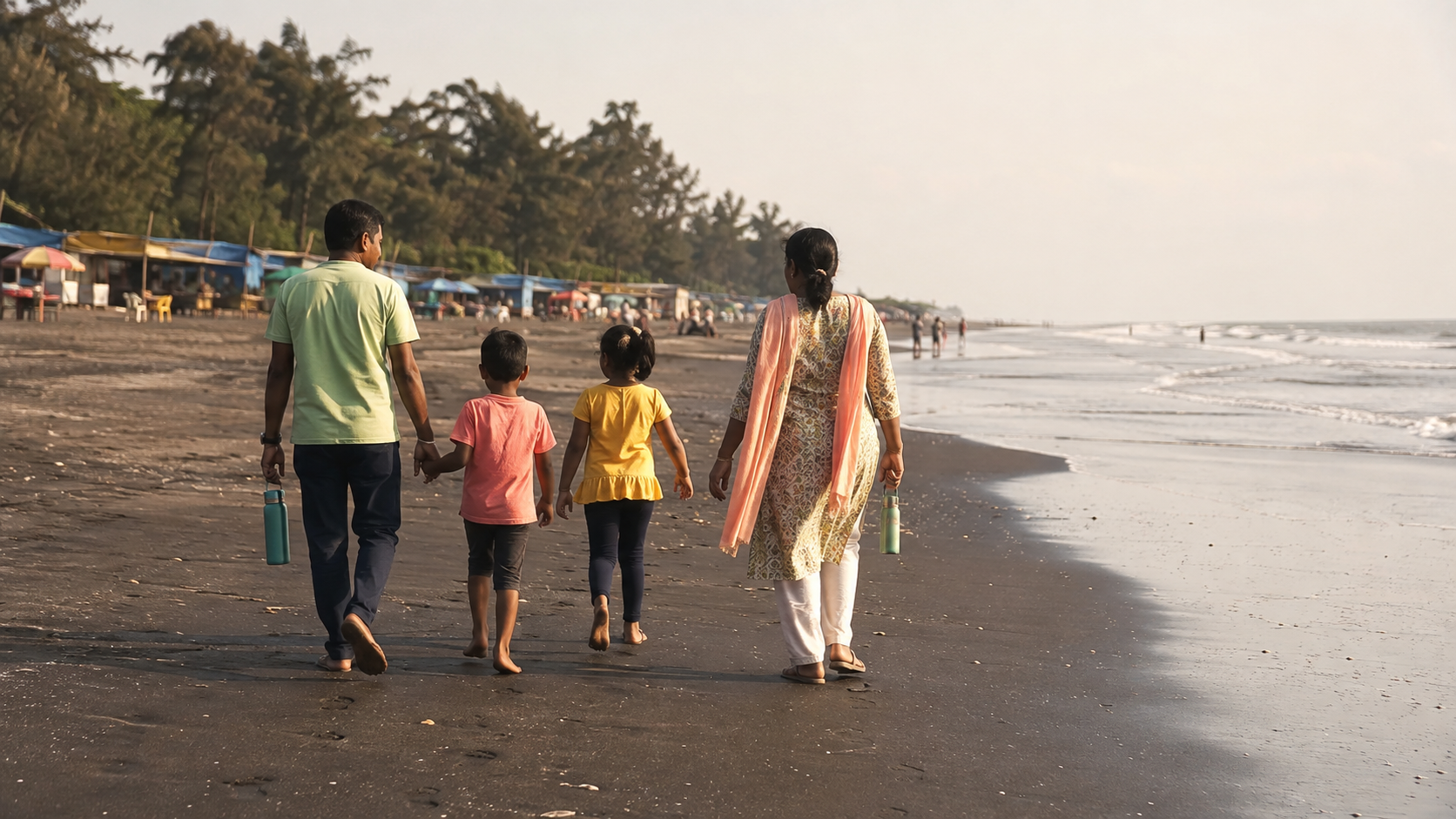Gujarati family walking on the dark sand at Ubharat Beach near Navsari
